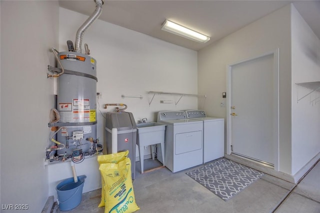 laundry area featuring strapped water heater, washing machine and clothes dryer, and laundry area