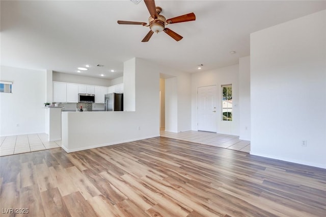 unfurnished living room featuring ceiling fan, baseboards, light wood-style flooring, and recessed lighting