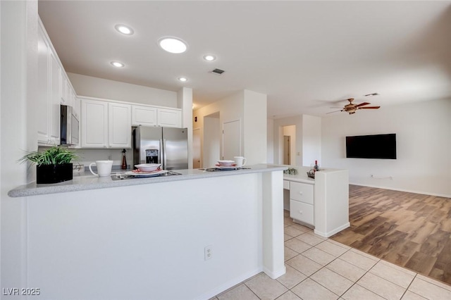 kitchen featuring light tile patterned floors, appliances with stainless steel finishes, white cabinetry, ceiling fan, and a peninsula