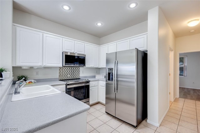 kitchen with light tile patterned floors, stainless steel appliances, a sink, and light countertops