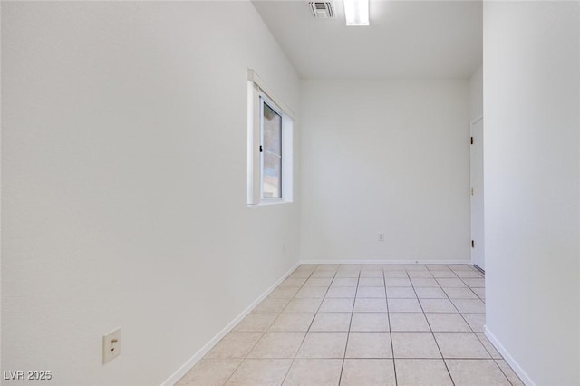 spare room featuring light tile patterned floors, visible vents, and baseboards