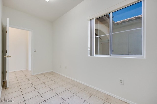 spare room featuring tile patterned flooring and baseboards