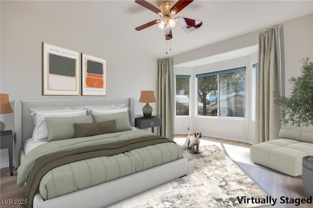 bedroom with ceiling fan, visible vents, and wood finished floors