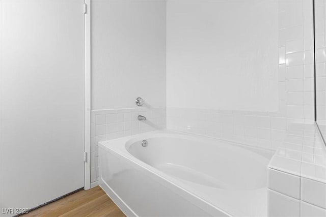 bathroom with hardwood / wood-style floors and a bathtub