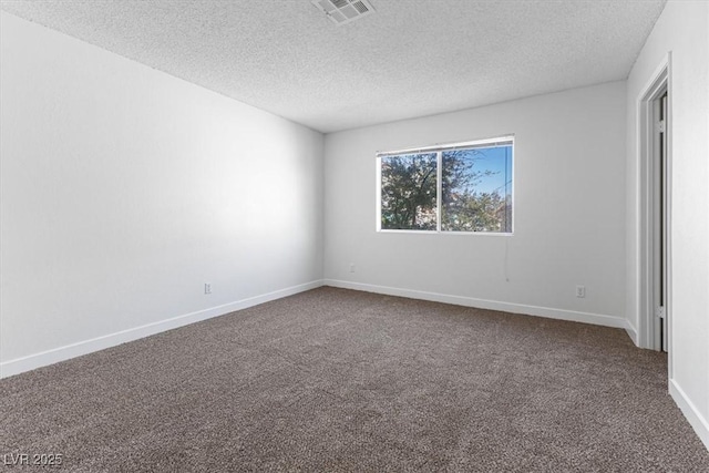 spare room featuring a textured ceiling and carpet