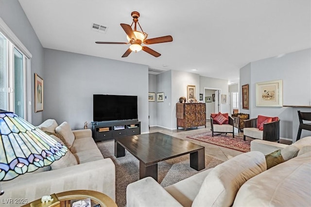 living room featuring ceiling fan and a wealth of natural light