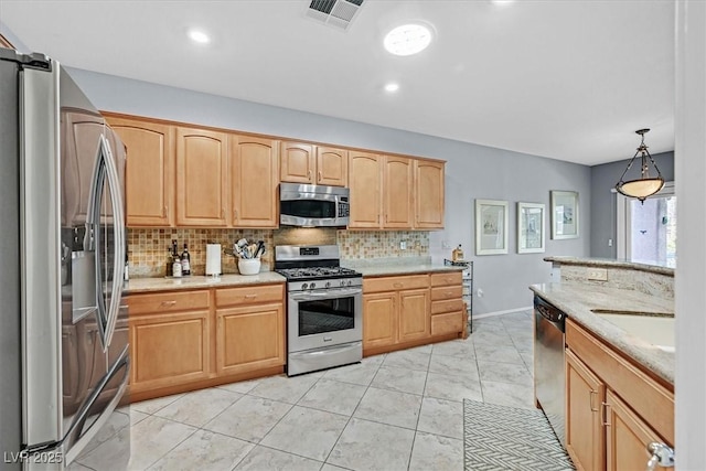 kitchen featuring appliances with stainless steel finishes, decorative light fixtures, tasteful backsplash, sink, and light brown cabinets