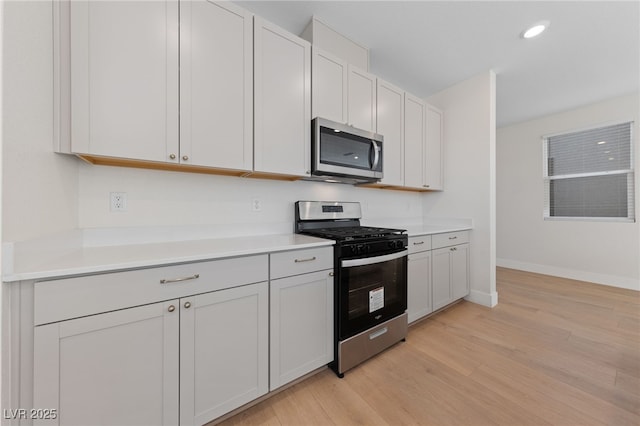 kitchen featuring white cabinetry, stainless steel appliances, and light wood-type flooring