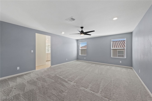 carpeted spare room featuring ceiling fan