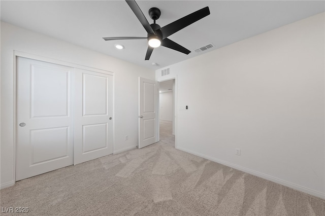 unfurnished bedroom featuring light carpet, a closet, and ceiling fan