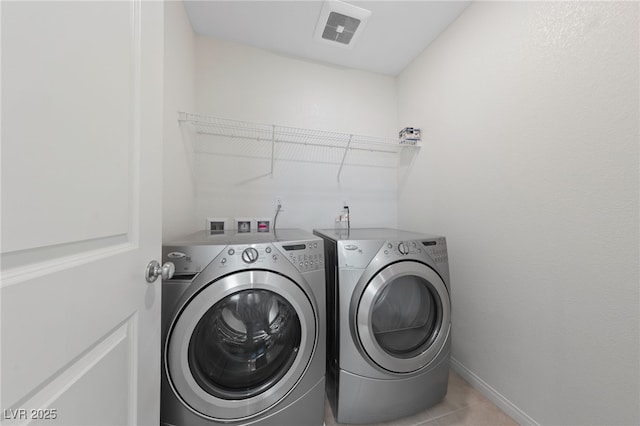 laundry room with light tile patterned flooring and washer and clothes dryer