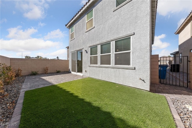 back of house with a patio area and a lawn