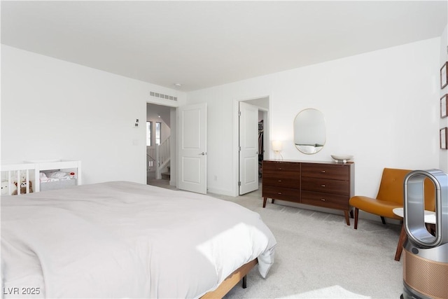 bedroom featuring a spacious closet and light colored carpet