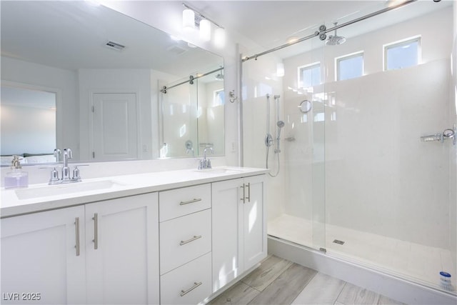 bathroom featuring a shower with door, vanity, and hardwood / wood-style flooring