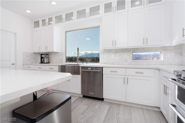 kitchen with white cabinetry, appliances with stainless steel finishes, sink, and backsplash