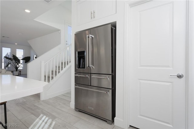 kitchen with white cabinetry, high end refrigerator, and light hardwood / wood-style floors