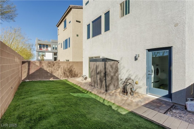 rear view of property with a yard and independent washer and dryer