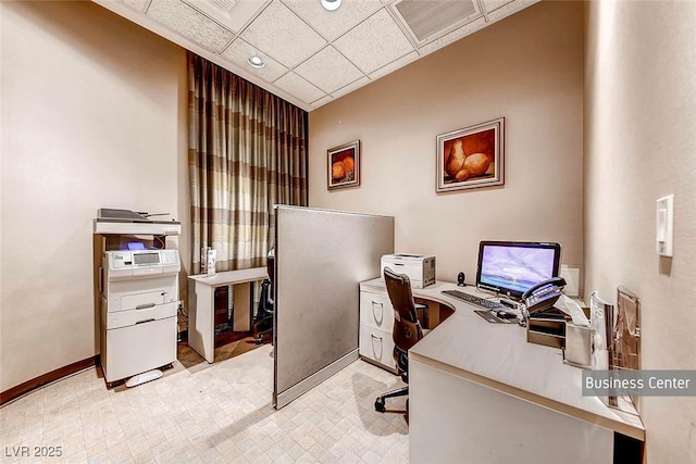 home office with visible vents, baseboards, and a drop ceiling