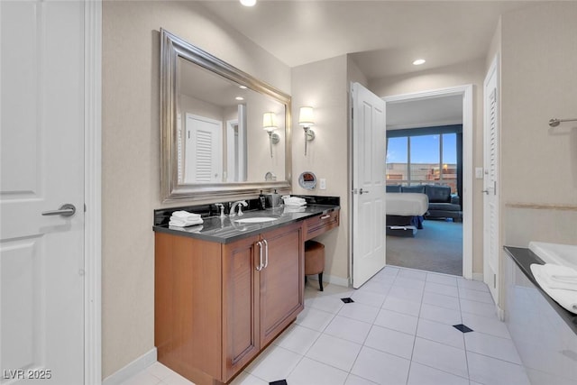 ensuite bathroom with tile patterned flooring, recessed lighting, vanity, baseboards, and ensuite bath