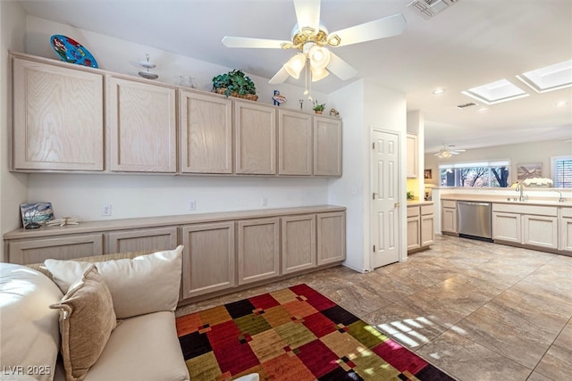 kitchen with sink, ceiling fan, dishwasher, a skylight, and light brown cabinets