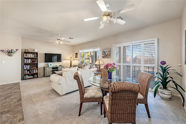 dining room with ceiling fan and light carpet