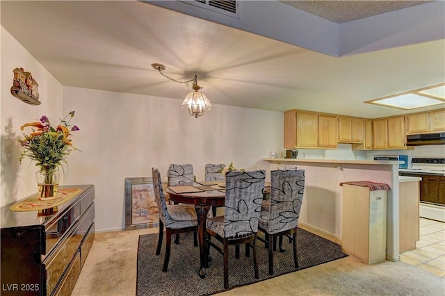 carpeted dining area with a notable chandelier and a textured ceiling