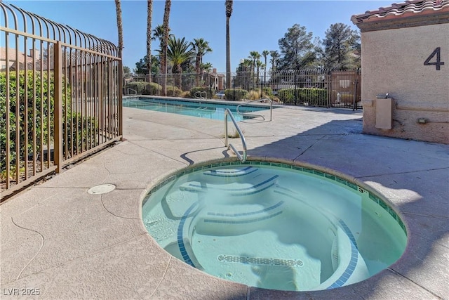 view of pool with a hot tub and a patio