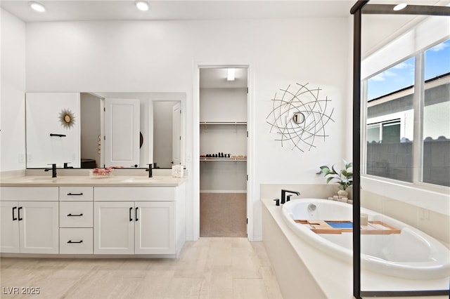 bathroom with a washtub and vanity