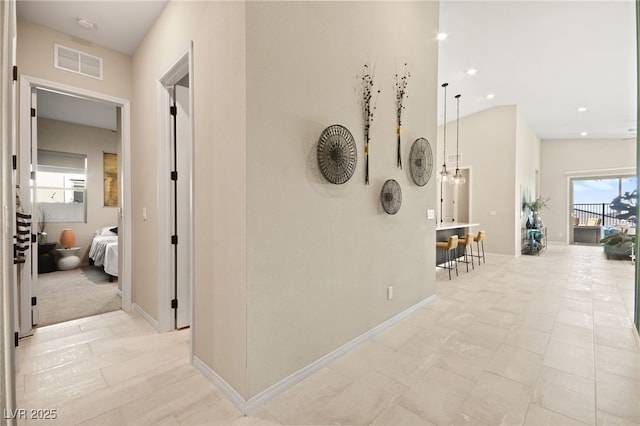 corridor with an inviting chandelier, light tile patterned floors, and a healthy amount of sunlight