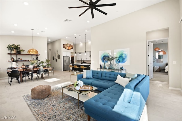 living room featuring ceiling fan, a towering ceiling, and sink