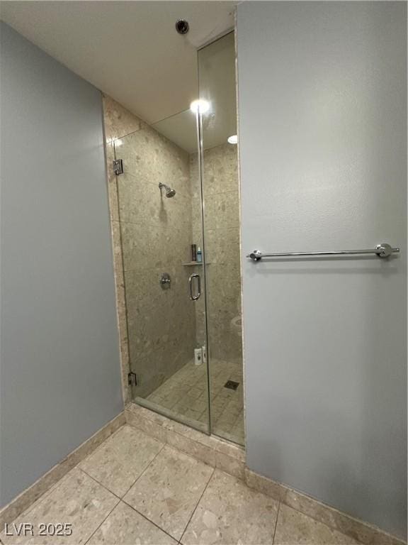 bathroom with an enclosed shower and tile patterned floors