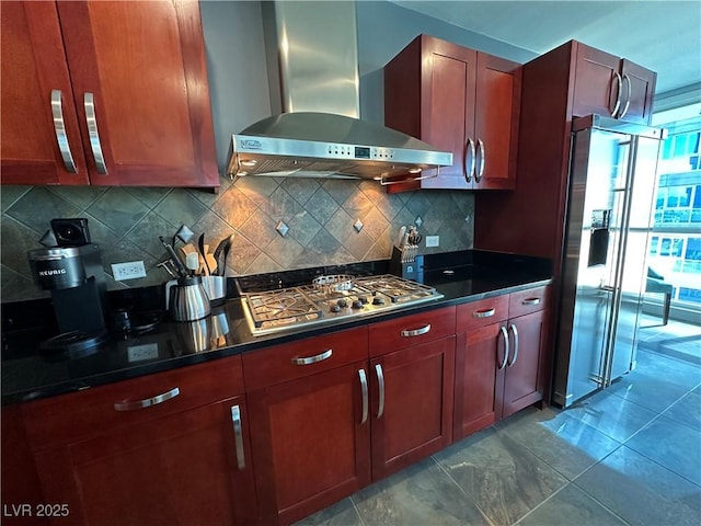 kitchen featuring wall chimney range hood, decorative backsplash, and stainless steel appliances