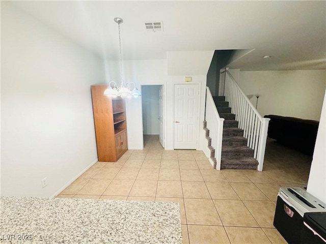 interior space featuring light tile patterned floors and a notable chandelier