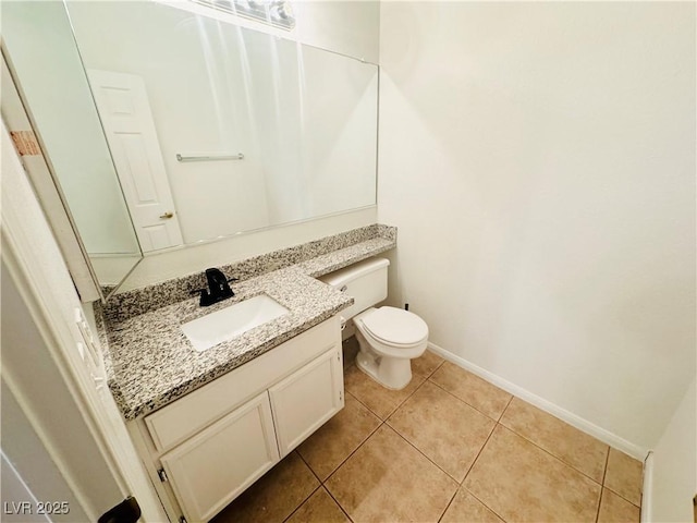 bathroom with tile patterned flooring, vanity, and toilet