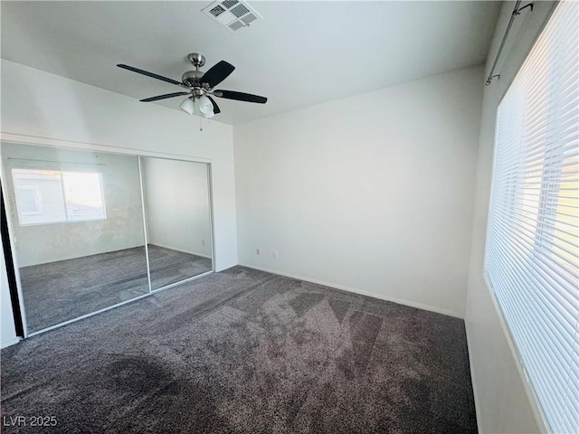 unfurnished bedroom with carpet floors, ceiling fan, and a closet