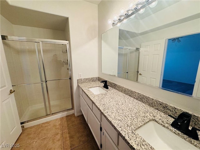 bathroom featuring a shower with door, vanity, and tile patterned floors