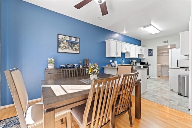 dining area featuring ceiling fan, sink, and light hardwood / wood-style floors