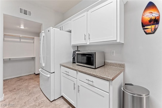 kitchen with white cabinets and white refrigerator