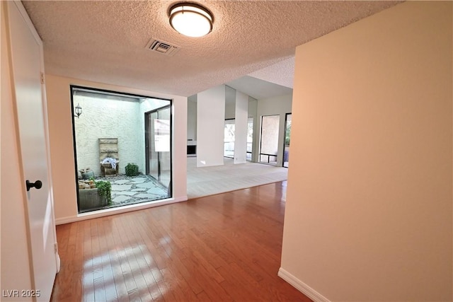 hall featuring hardwood / wood-style flooring and a textured ceiling