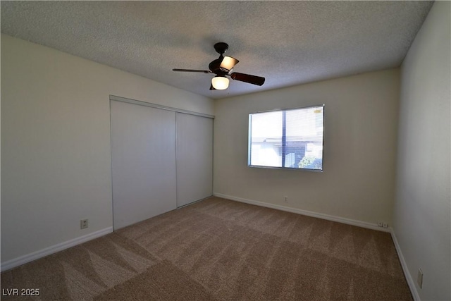 unfurnished bedroom with ceiling fan, a closet, a textured ceiling, and carpet flooring