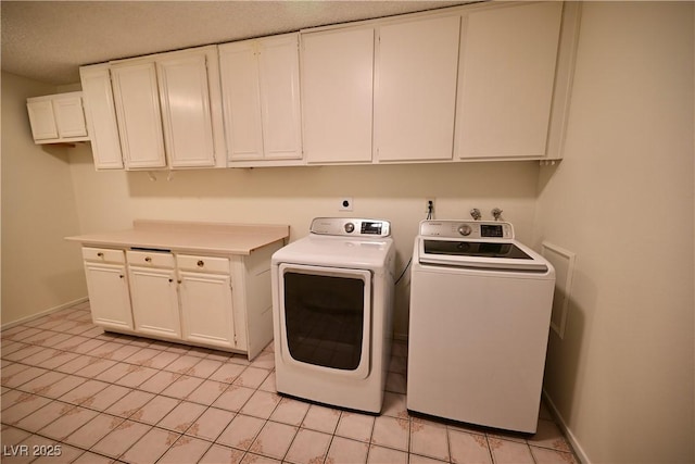 washroom featuring light tile patterned floors, cabinets, and washing machine and clothes dryer