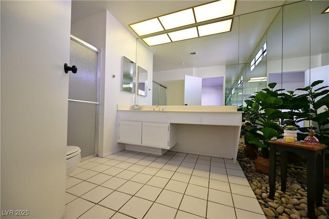 bathroom with vanity, toilet, tile patterned floors, and a shower with shower door