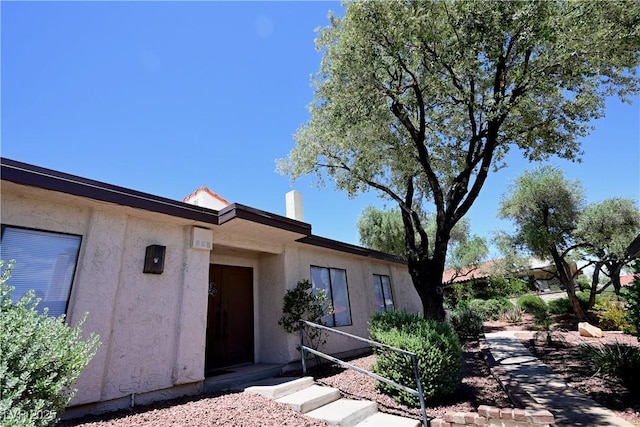 3126 Asoleado Cir, Las Vegas, NV 89121 - view of exterior entry with stucco siding and a chimney