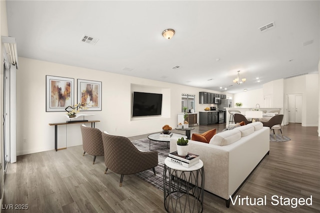 living room featuring wood-type flooring and a notable chandelier