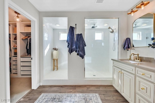 bathroom featuring a tile shower, vanity, and hardwood / wood-style flooring