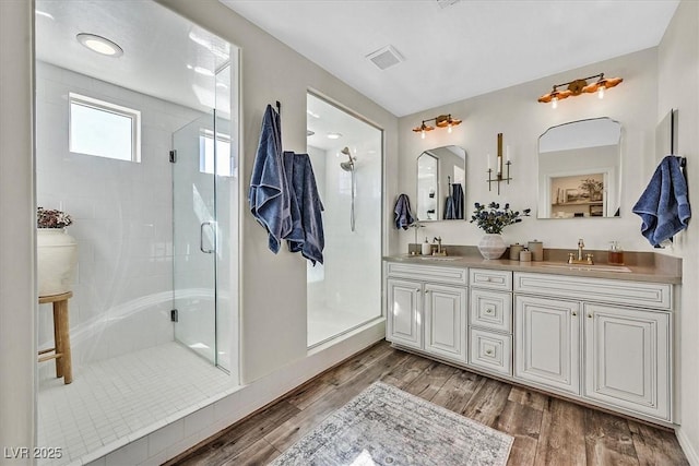 bathroom with hardwood / wood-style flooring, vanity, and an enclosed shower