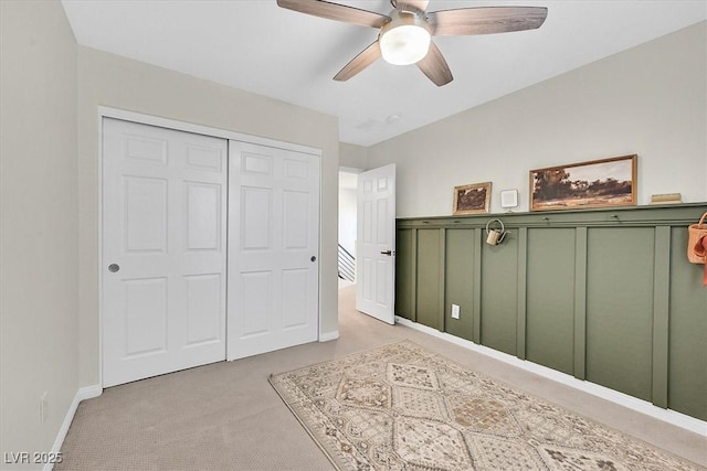 carpeted bedroom featuring a closet and ceiling fan