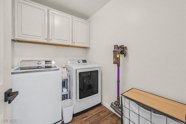 washroom featuring dark hardwood / wood-style floors, washing machine and dryer, and cabinets