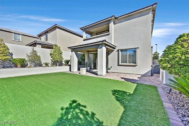 back of property featuring a patio area and a lawn