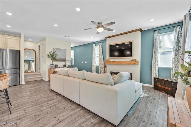 living room with ceiling fan and light wood-type flooring